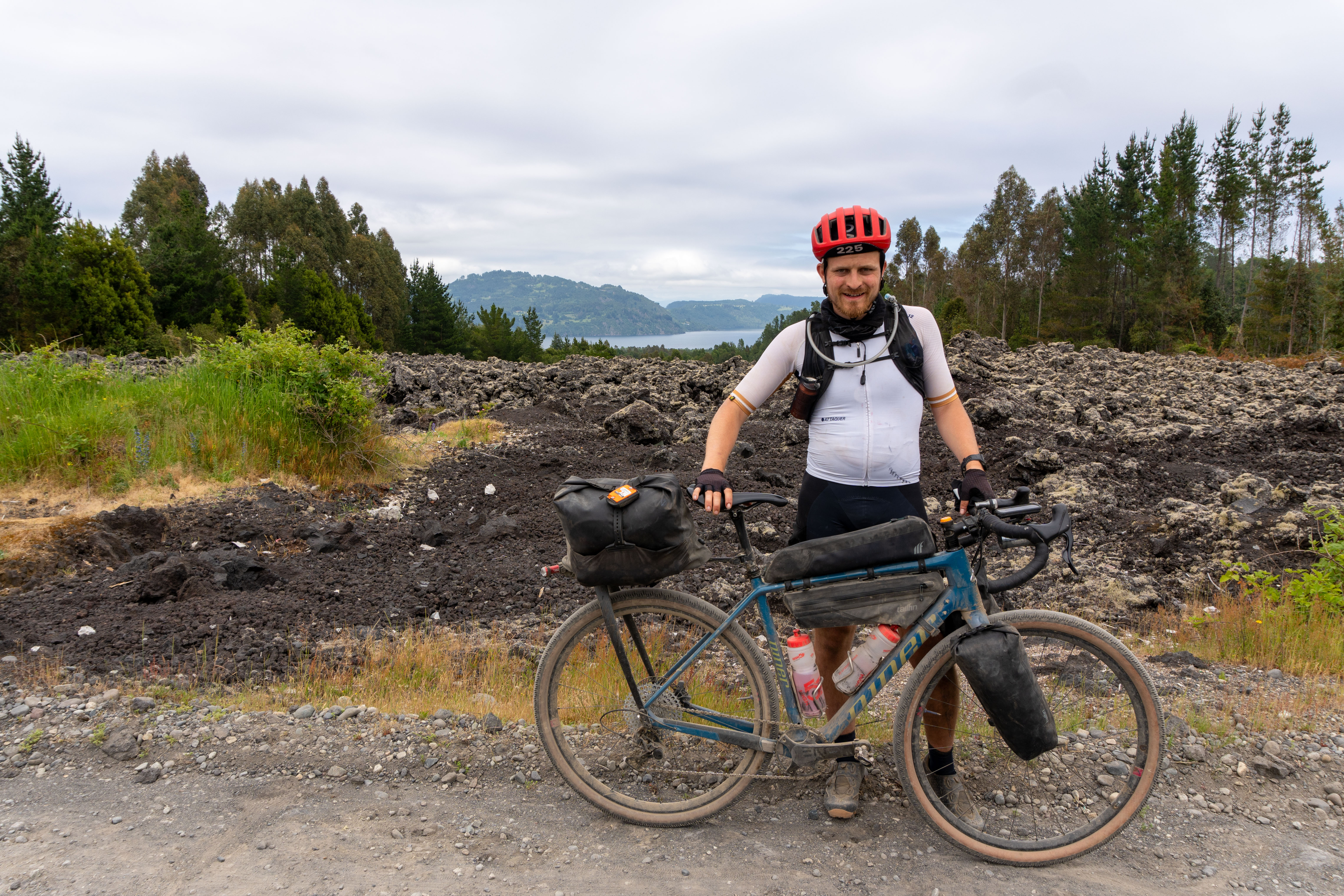 Oscar Huckle standing with Niner RLT 9 RDO gravel bike against a lake